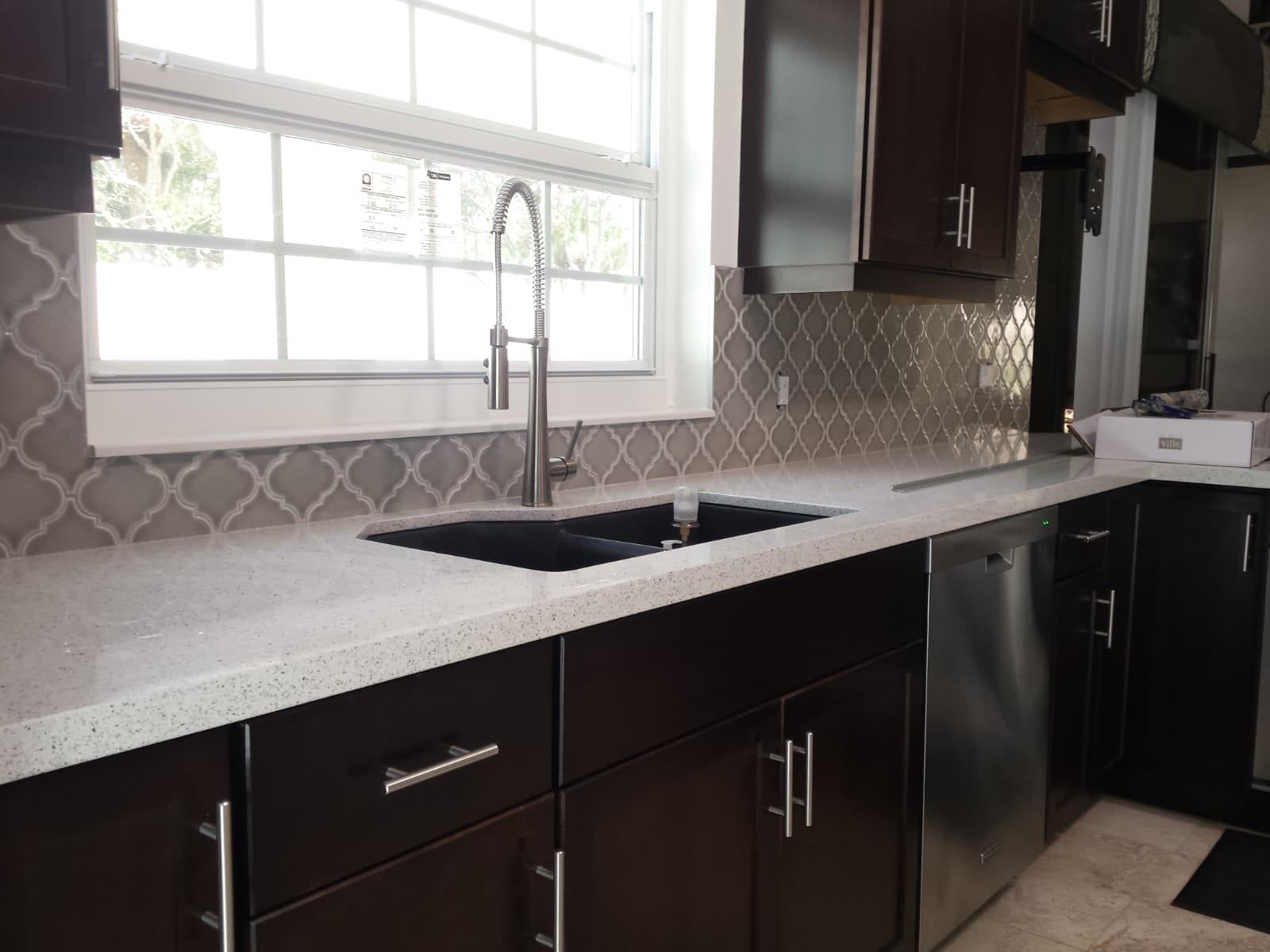 Arabesque backsplash along the sink wall, cut clean around the window and the outlets